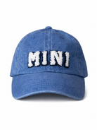 Blue denim cap with white fuzzy letters spelling "MINI" on the front. Ideal for casual outfits.