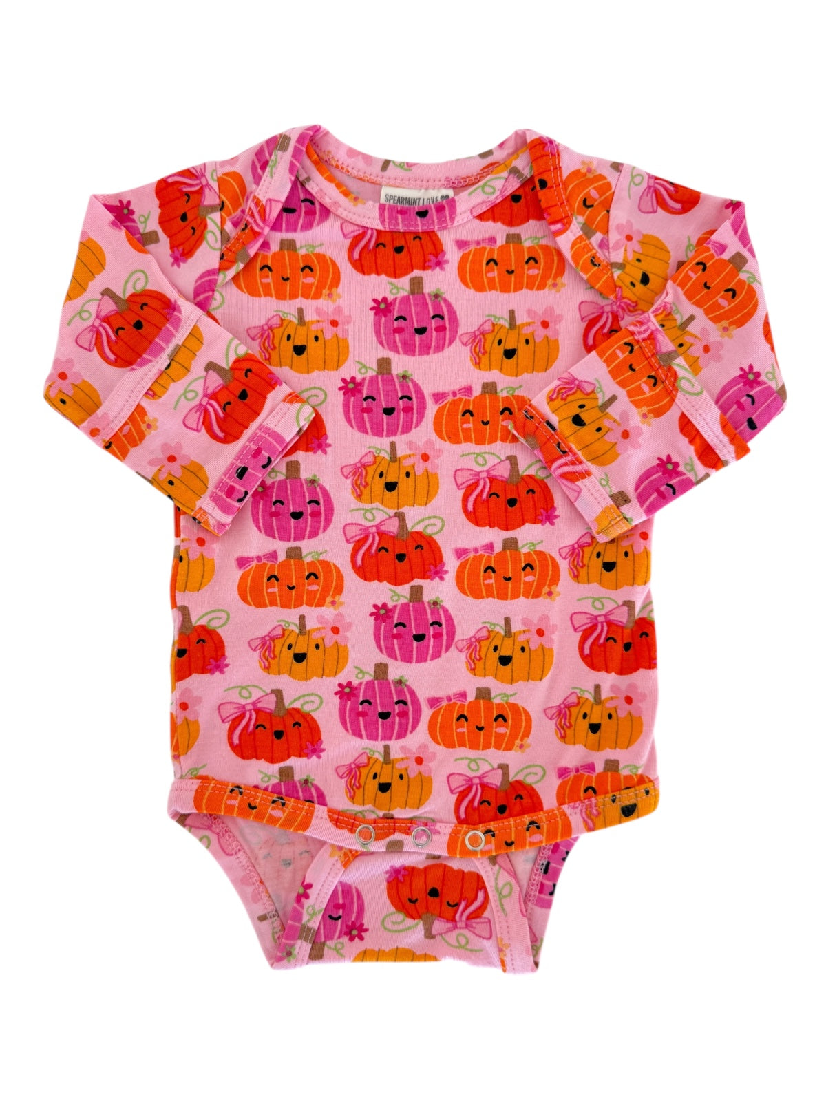 Pink long-sleeve onesie featuring colorful, smiling pumpkins in various expressions and designs.