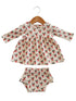 Girls' dress and matching bloomers with a floral pattern, hanging on a wooden hanger.