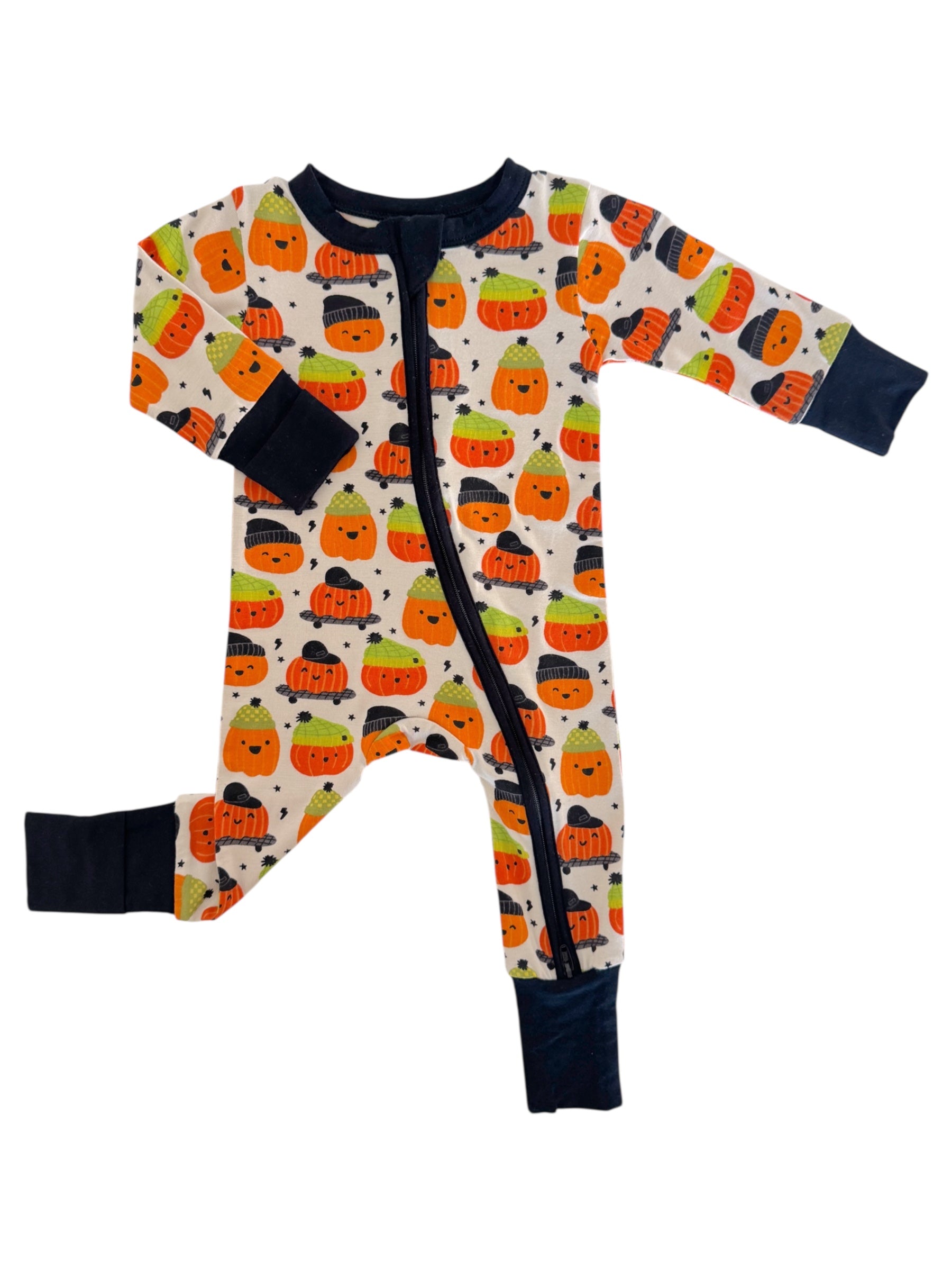Child's pajama onesie featuring colorful pumpkin patterns on a light background with navy cuffs and zipper.