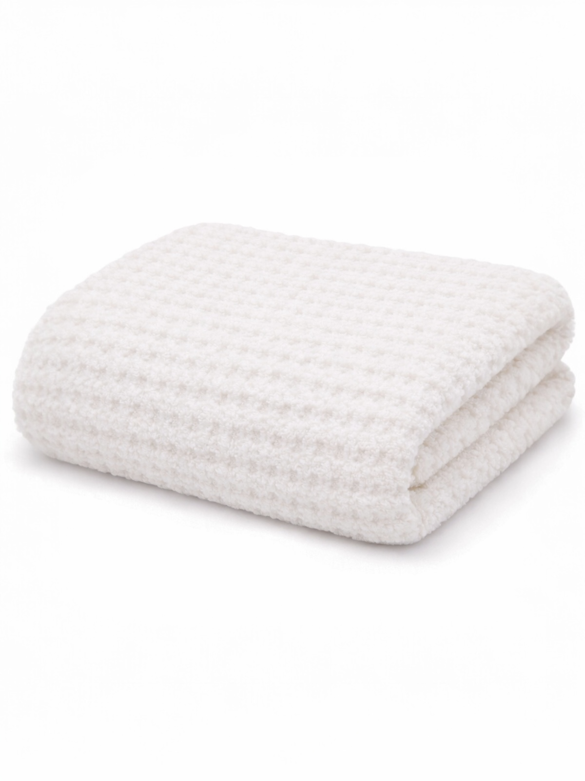 Folded white textured blanket on a light background, soft and cozy for home decor or comfort.
