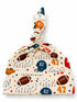 Football-themed baby hat with cute illustrations of helmets, footballs, and stars, tied at the top.