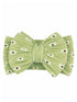 Green floral hair bow with a pleated design and small white flowers, centered by a matching ribbon.