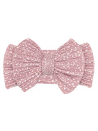Pink fabric hair bow with textured pattern and a central knot detail. Ideal accessory for children or women's fashion.