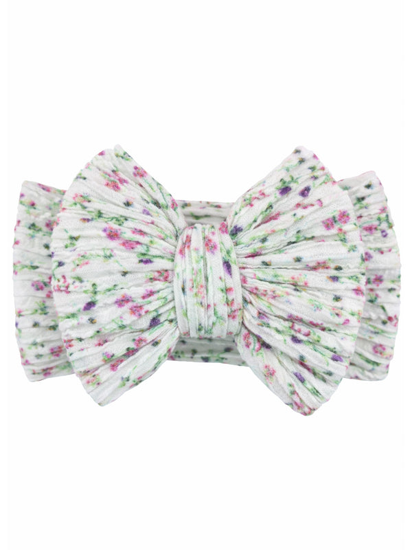 Floral-patterned hair bow in soft white fabric with pink and green accents. Perfect for adding a cute touch to hairstyles.