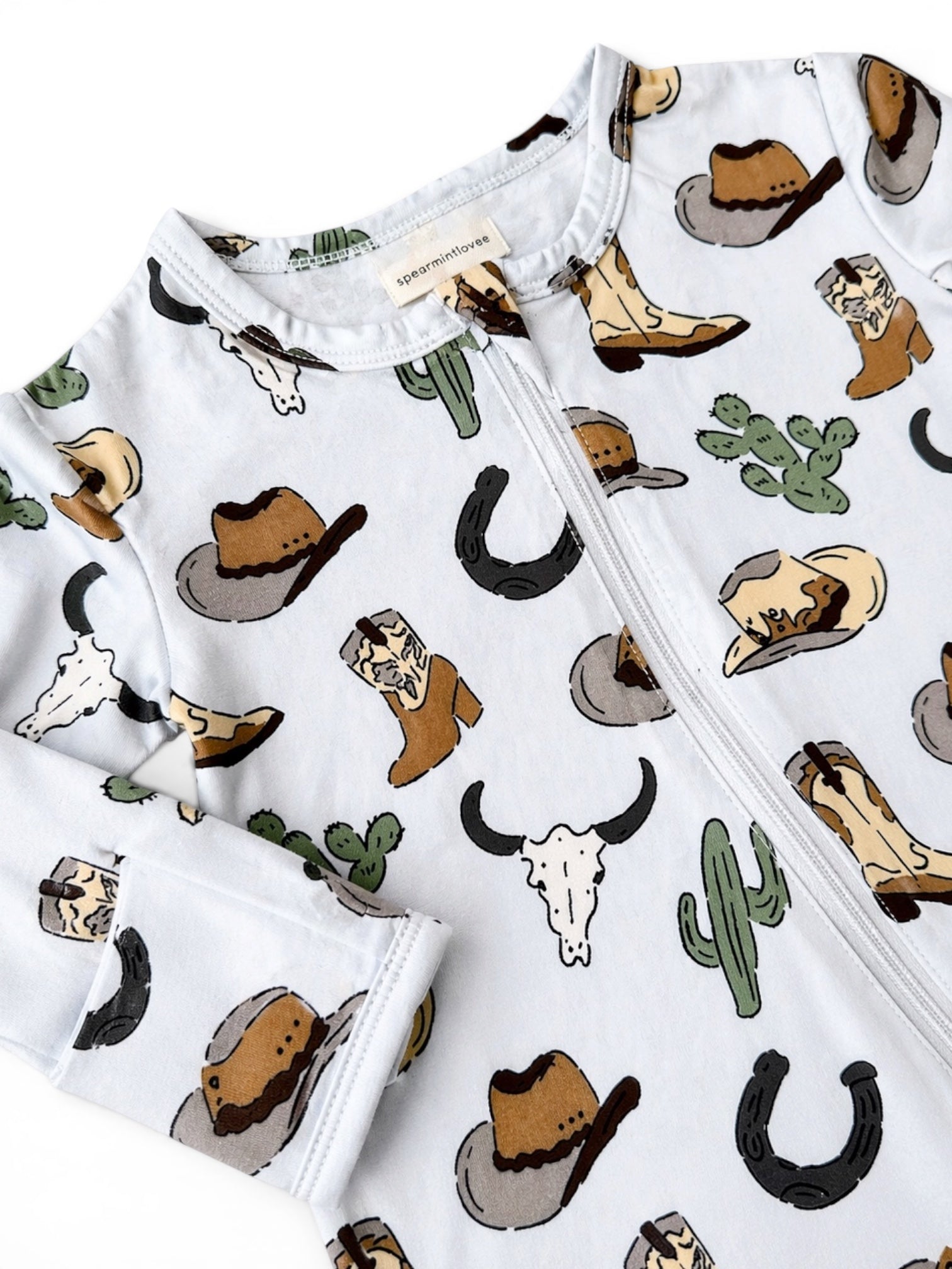 Cowboy-themed baby onesie featuring hats, boots, cacti, and western motifs on a light background.
