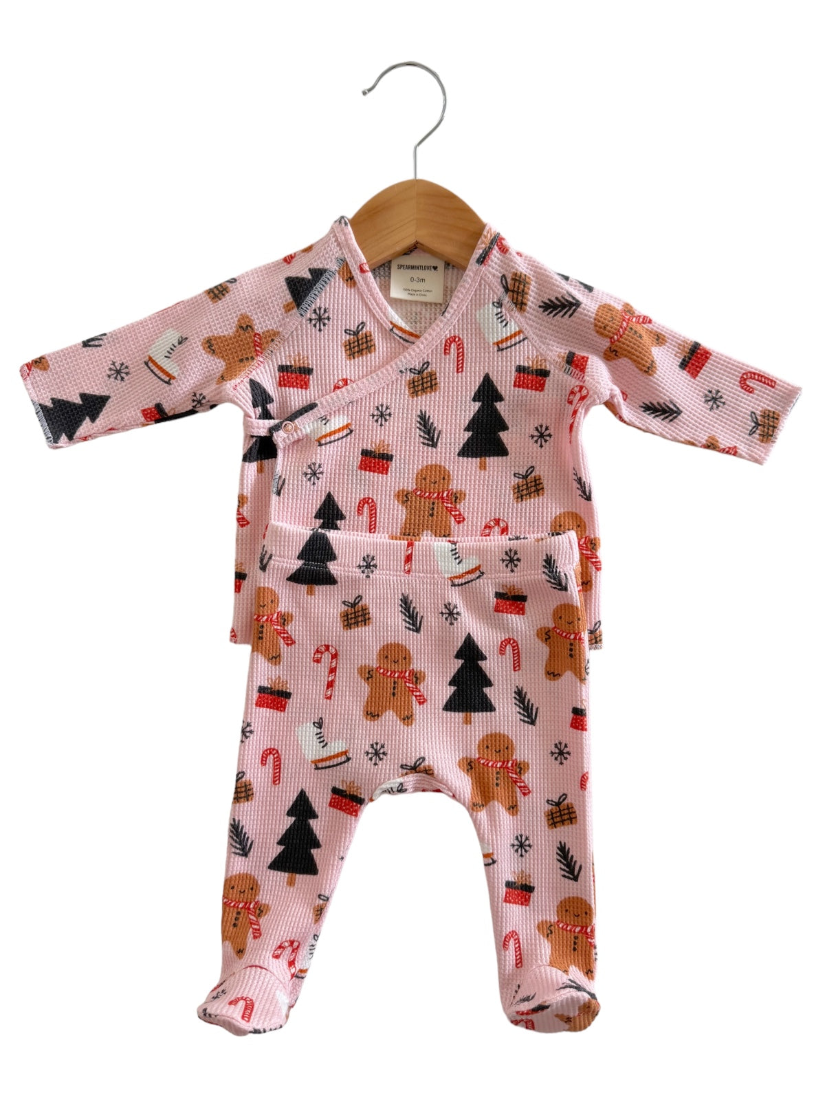 Pink baby outfit with gingerbread and holiday patterns, featuring a wrap top and matching pants.