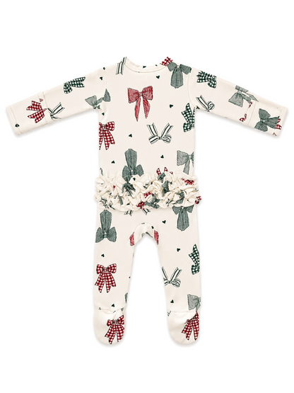 Infant onesie with festive bow patterns in red and green on a cream background, featuring ruffled waist details.