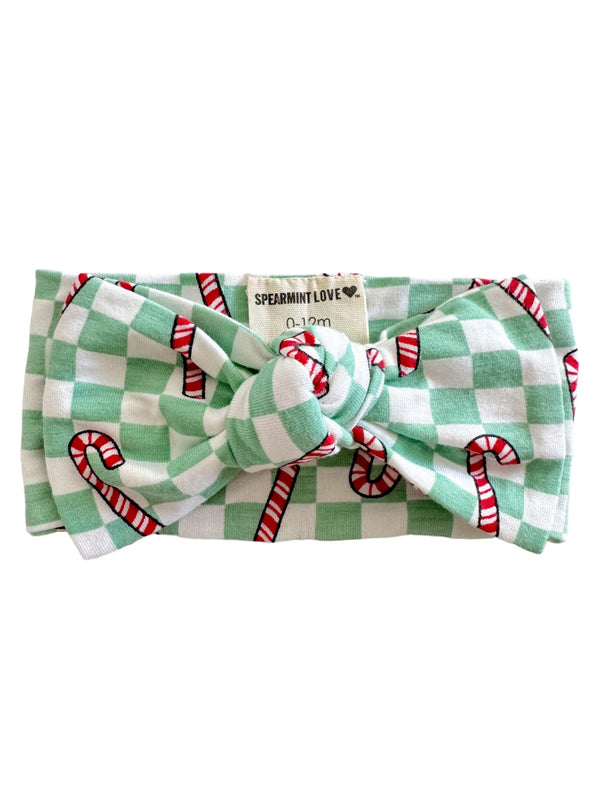 Green and white checkered bow headband with candy cane prints, suitable for infants 0-12 months.