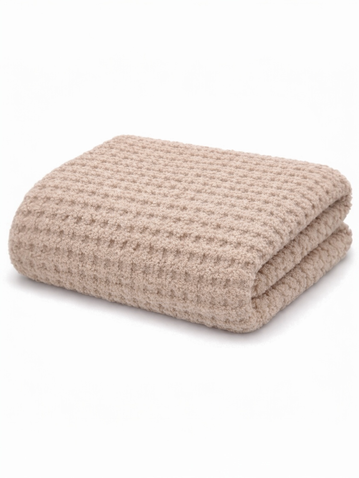 Beige waffle-patterned blanket folded neatly on a white background. Soft and cozy texture.
