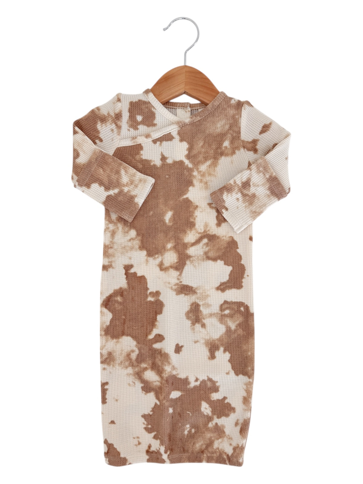 Brown and cream tie-dye dress hanging on a wooden hanger against a white background.