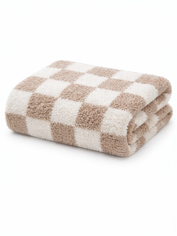 Folded beige and white checkered towel on a white background. Soft texture suitable for bath use.
