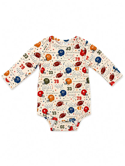 Cream-colored baby onesie with football and helmet patterns in various colors and numbers.