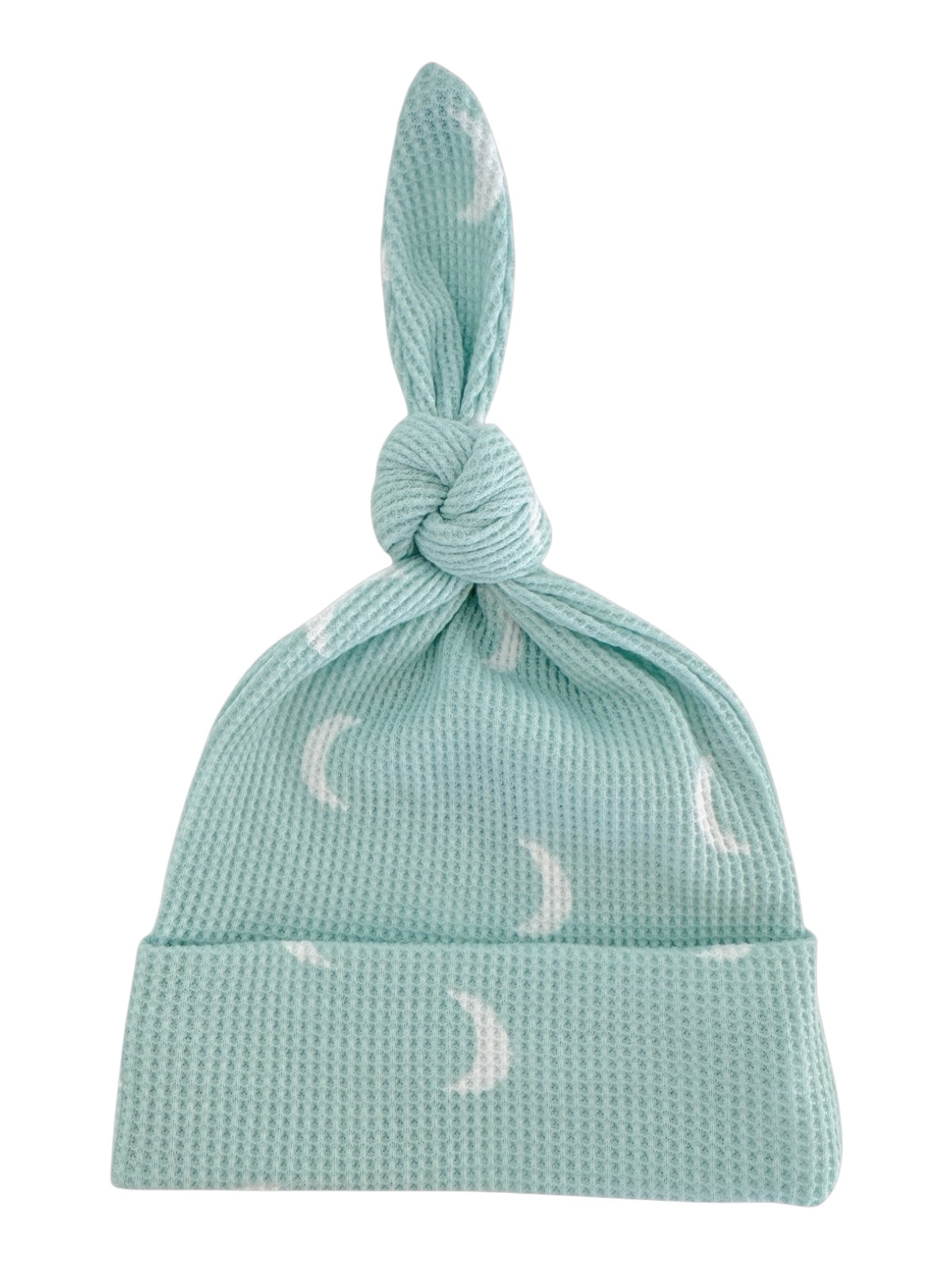 Light blue baby hat with a knot on top and white crescent moon patterns.