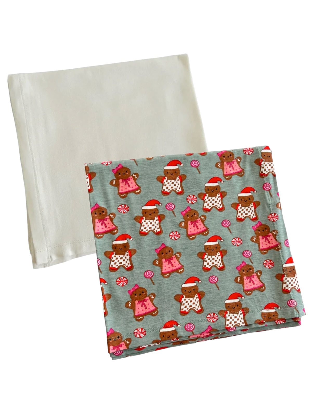A patterned cloth featuring gingerbread characters and candy, alongside a plain white cloth.