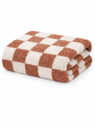 Brown and cream checkered towel, neatly folded with a soft, fluffy texture.