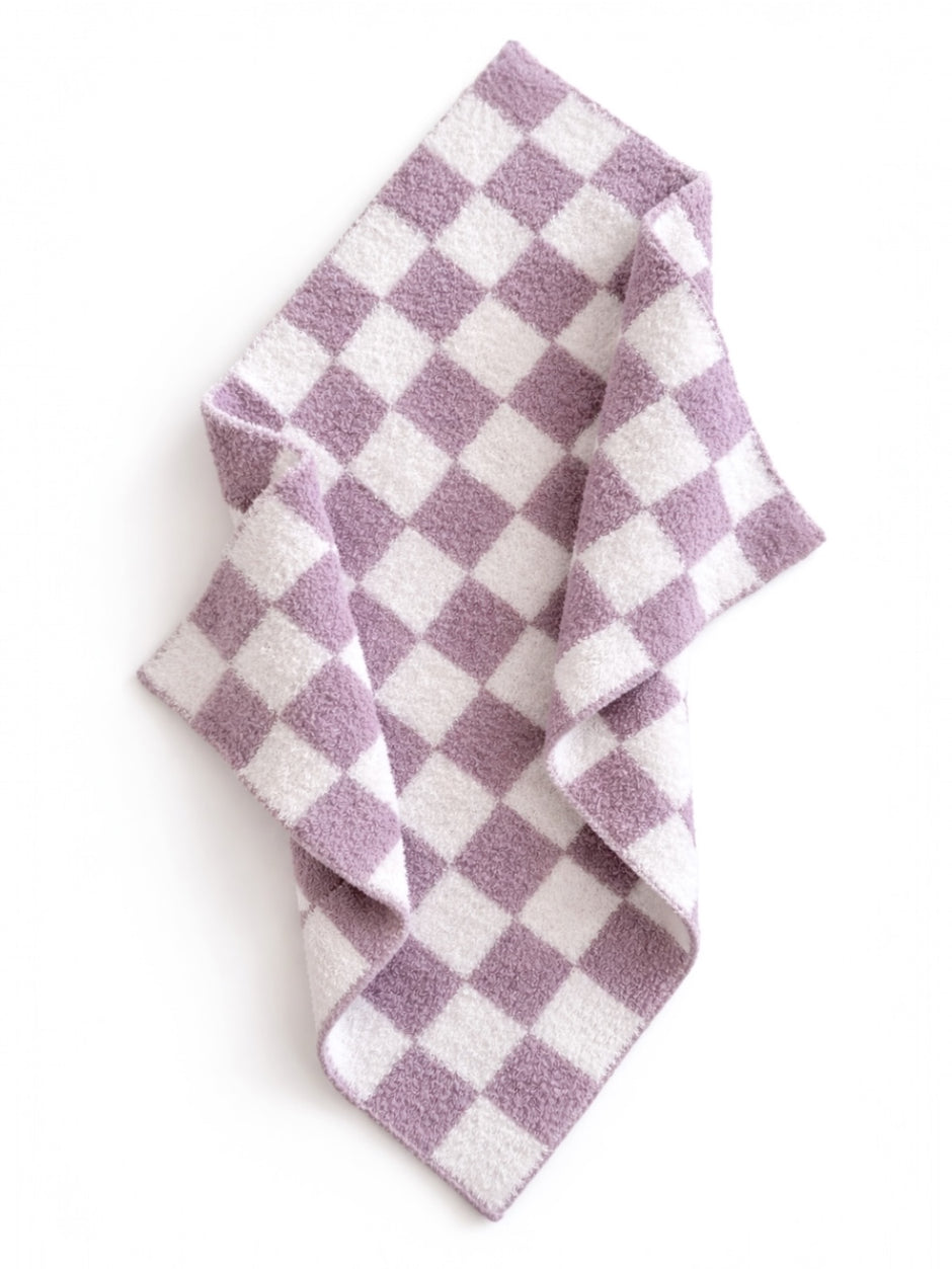 Purple and white checkered fabric draped on a flat surface, showcasing its soft texture and pattern.