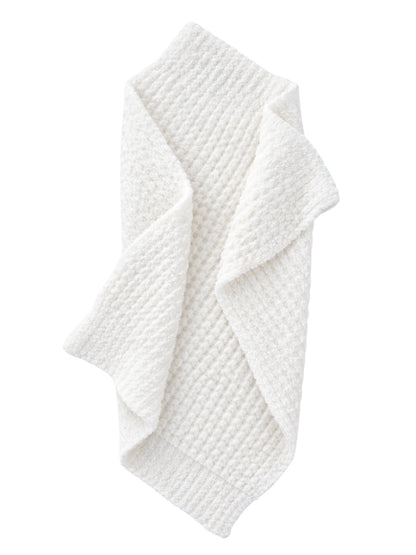 Textured white blanket draped elegantly, showcasing its cozy and soft appearance.
