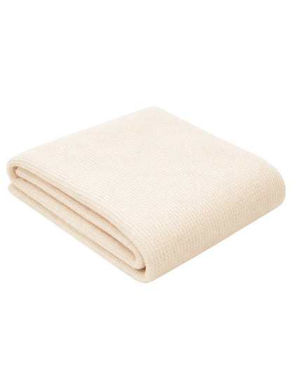 Cream-colored folded blanket with a textured weave, perfect for warmth and comfort.