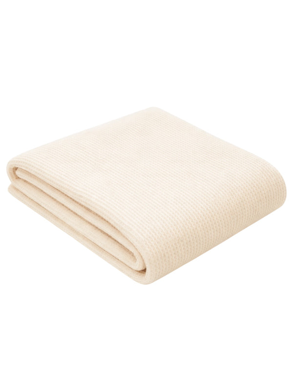 Cream-colored folded blanket with a textured weave, perfect for warmth and comfort.
