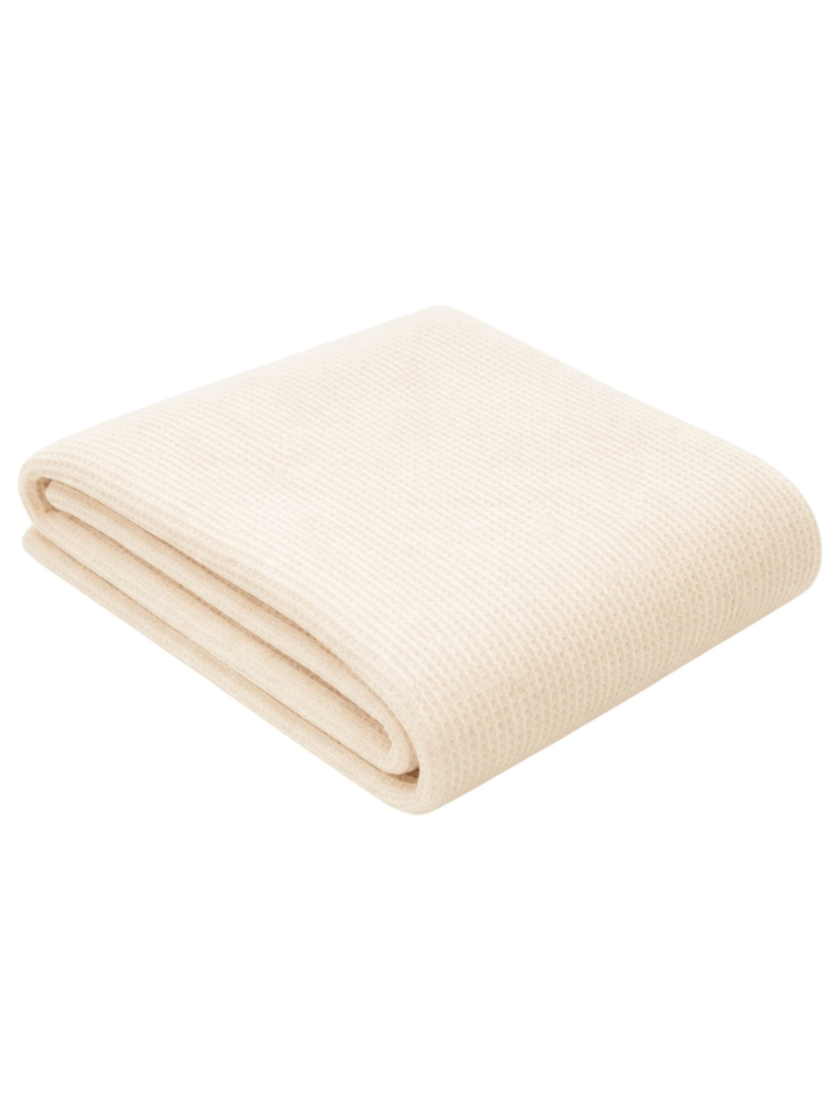 Cream-colored folded blanket with a textured weave, perfect for warmth and comfort.