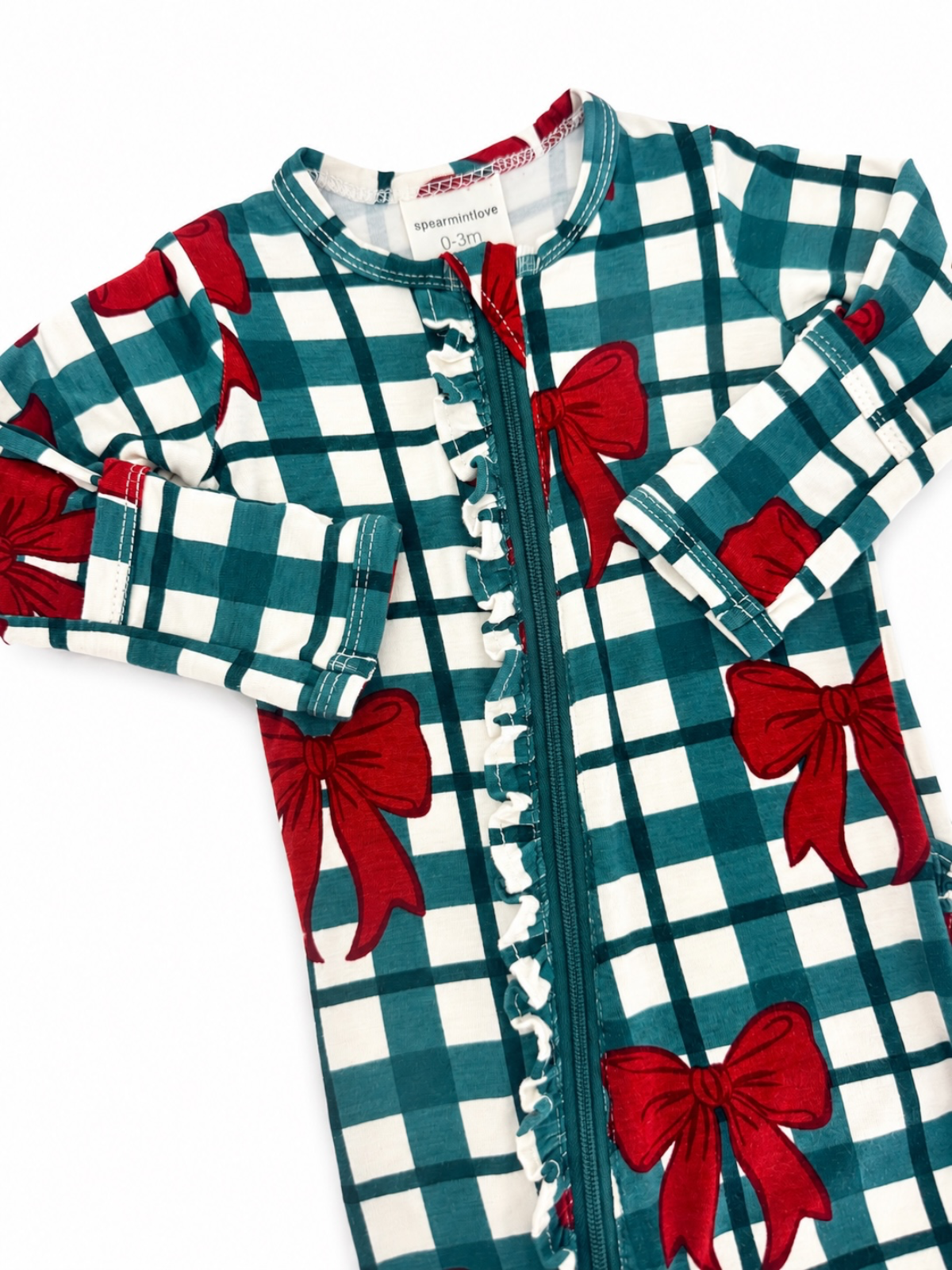 Patterned baby onesie with teal and white checkered fabric and red bows, featuring a zipper and ruffled details.
