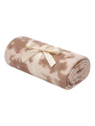 Rolled beige blanket with a tie, featuring a soft texture and subtle pattern. Ideal for comfort and decoration.