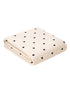 Cream-colored blanket with black heart patterns, folded neatly on a white background. Perfect for cozy settings.