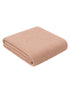 Light pink folded blanket showcasing a textured fabric, ideal for cozy home decor.