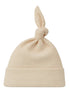 Cream-colored knit hat with a knot at the top and a folded brim. Ideal for newborns or chilly weather.