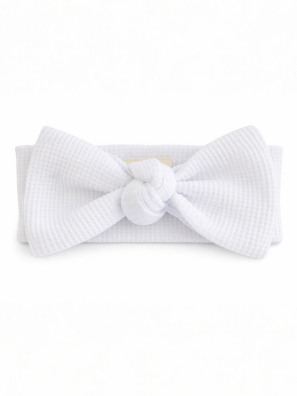 White textured headband with a large bow and knot detail at the center.