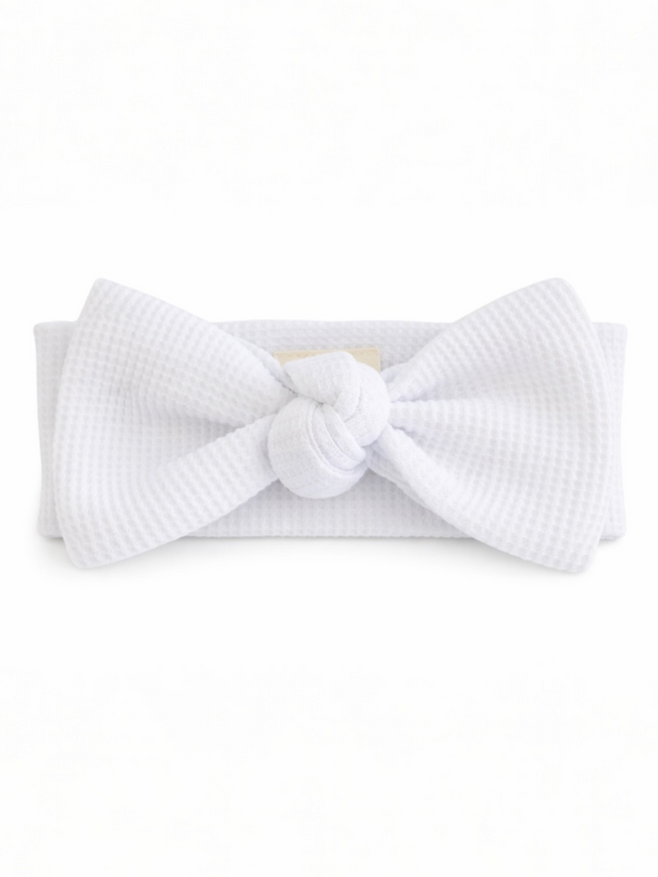 White textured headband with a large bow and knot detail at the center.