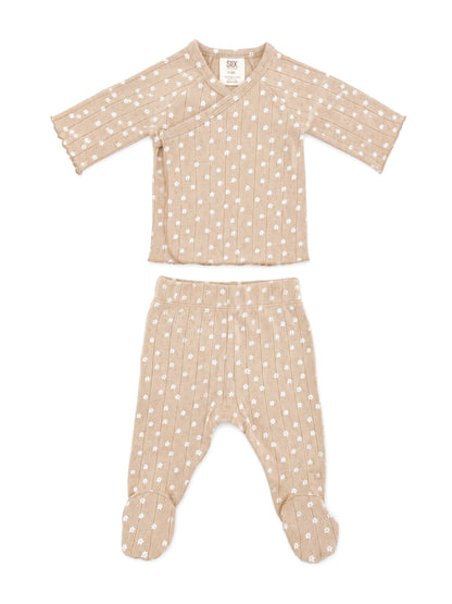 Beige baby outfit with white floral pattern, featuring a wrap top and footed pants. Ideal for infants.