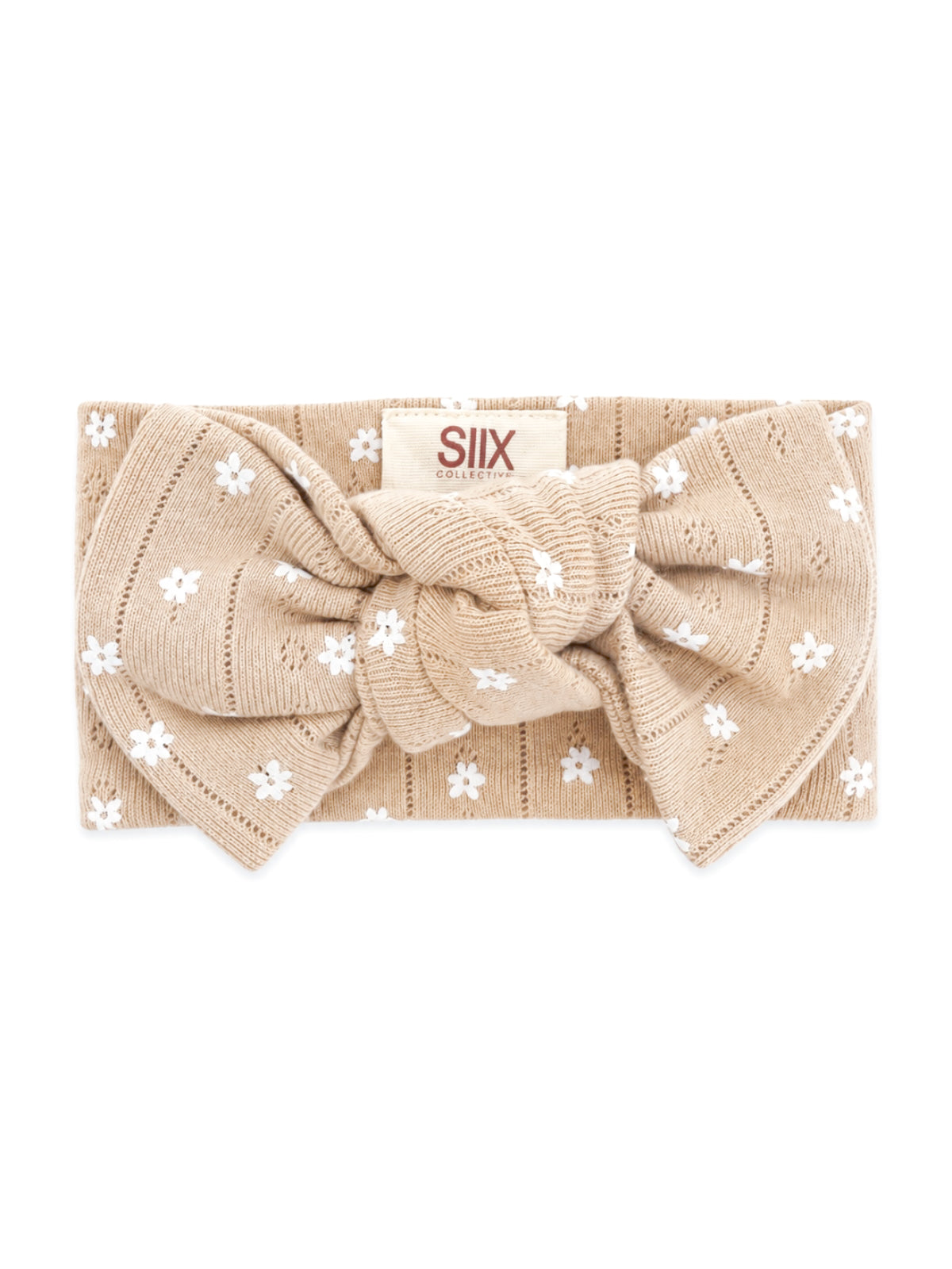 Beige headband with white floral patterns and a large bow, labeled "SIIX COLLECTIVE."