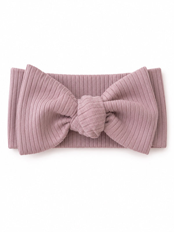 Light pink ribbed headband with a large bow detail, displayed on a white background.
