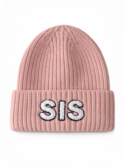 Pink knit beanie with "SIS" embroidered in white letters on the folded cuff.
