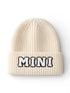 Cream-colored knit beanie with "MINI" embroidered in black and white letters.