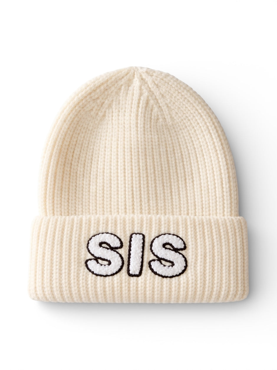 Cream-colored knit beanie with "SIS" embroidered in black and white on the front.