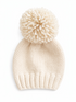 Cream-colored knit beanie with a fluffy pom-pom on top, resting on a white background.