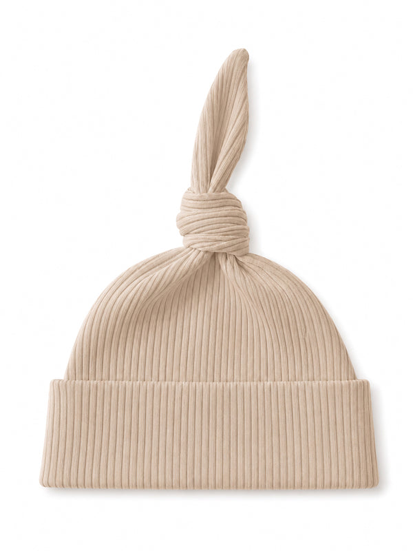 Beige ribbed knit hat with a knotted top and a folded brim, ideal for casual wear.