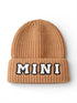 Brown knit beanie with a folded cuff featuring the word "MINI" in white and black letters.
