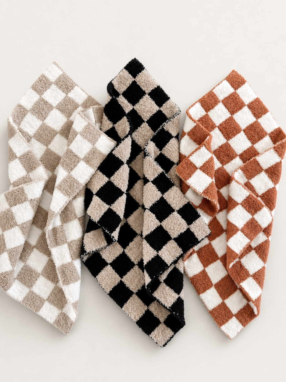 Checkered towels in beige, black, and rust colors displayed on a light background.