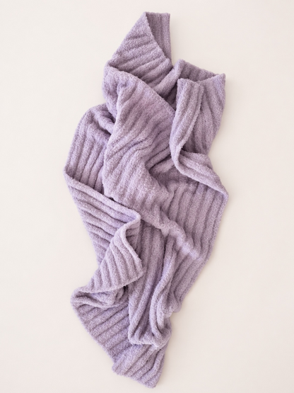 Lavender textured blanket draped on a light background, showcasing cozy design and softness.