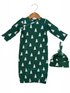 Green baby gown with white tree patterns, paired with a matching knotted hat, hanging on a wooden hanger.