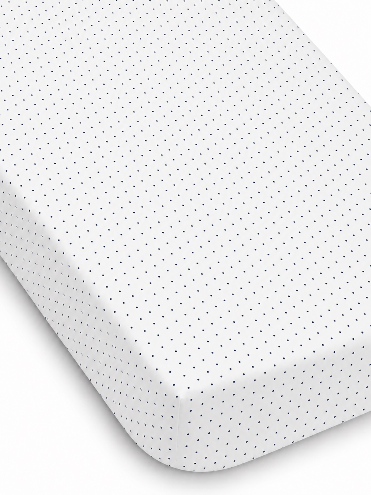 White fitted sheet with navy blue polka dots, showcasing texture and neat edges. Ideal for bedding decor.