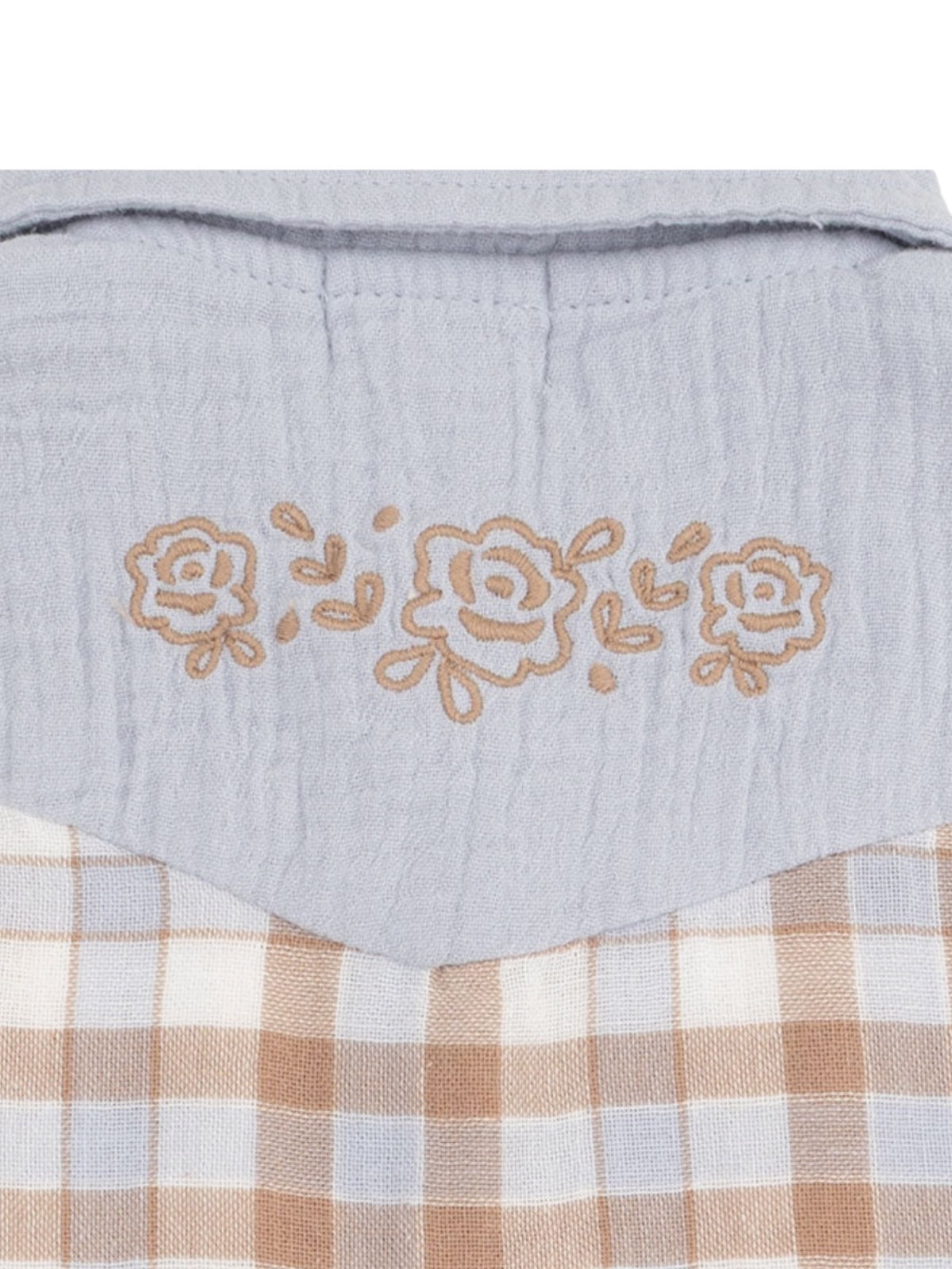 Light blue fabric with floral embroidery and a beige checkered pattern below.