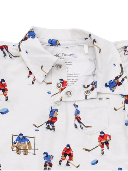 White polo shirt with hockey player illustrations and a collar, featuring buttons and a small chest pocket.