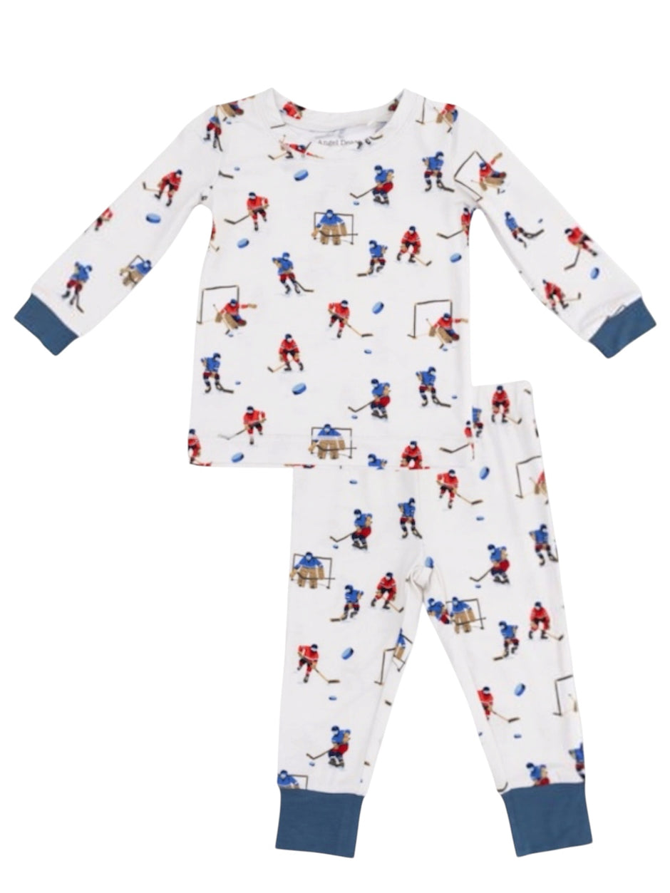Children's pajama set featuring hockey-themed patterns with players and equipment on a white background.