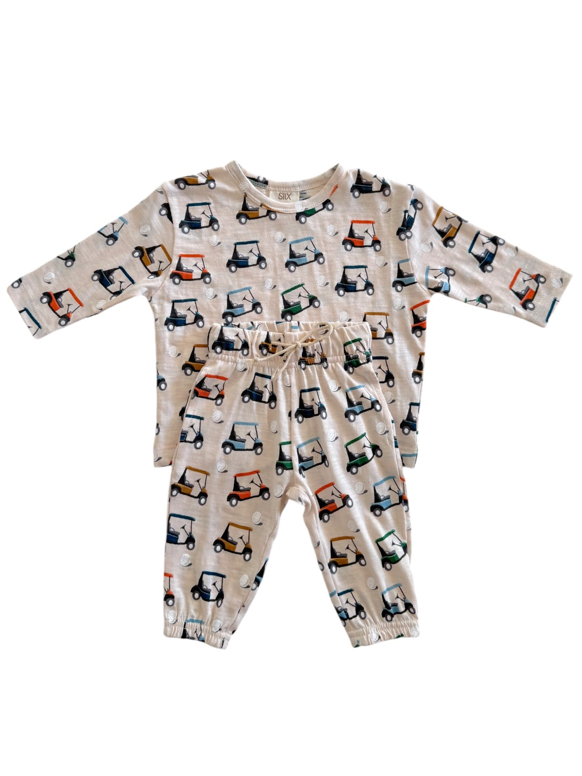 Children's two-piece outfit featuring a long-sleeve top and pants with colorful golf cart print on a beige background.