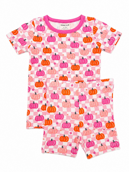 Pink pajamas with colorful pumpkin patterns, featuring a short-sleeve top and shorts. Perfect for cozy nights.